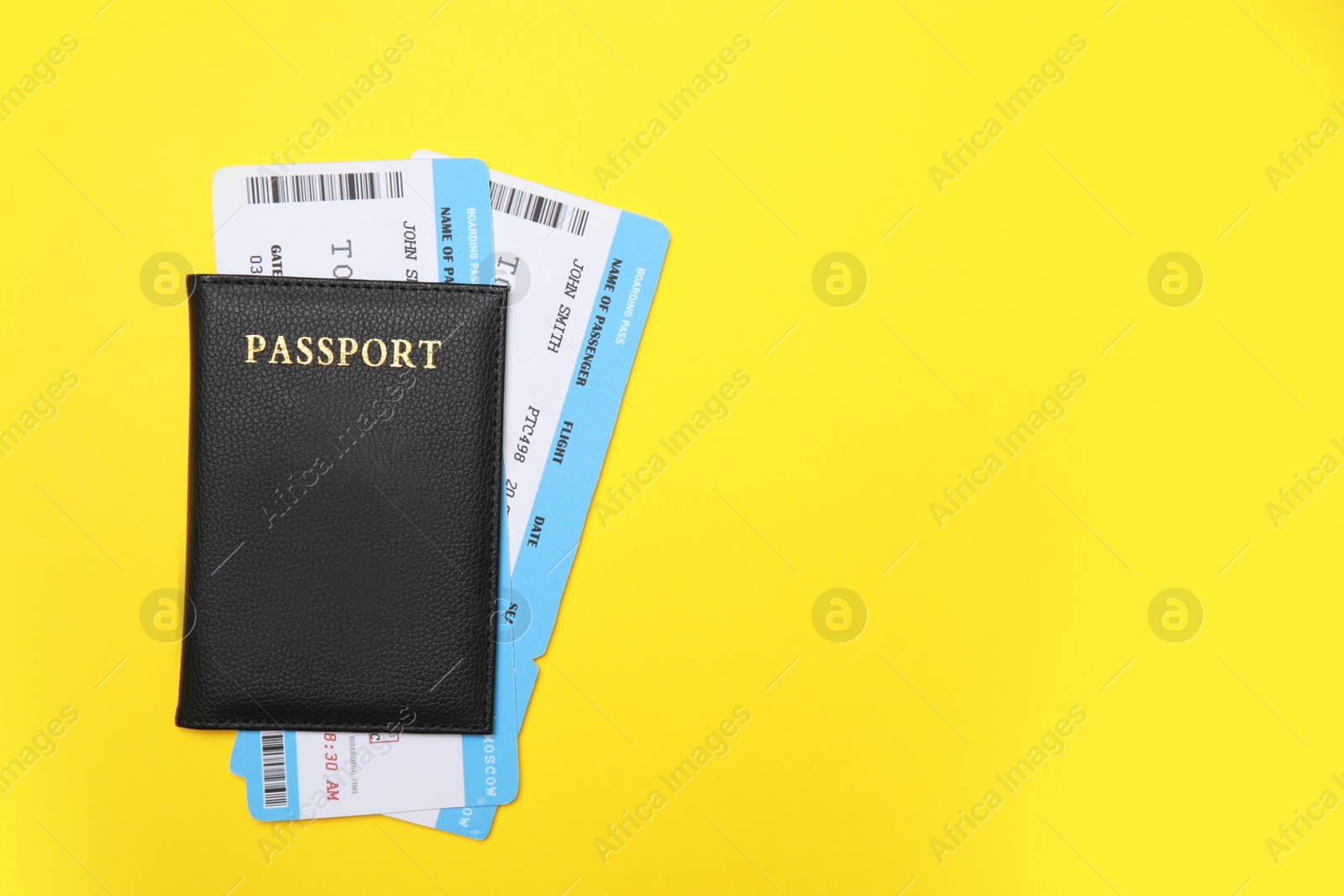 Photo of United States passport with tickets on yellow background, top view. Space for text