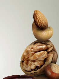 Image of Many different nuts on light grey gradient background, space for text