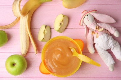 Photo of Flat lay composition with bowl of healthy baby food on wooden background