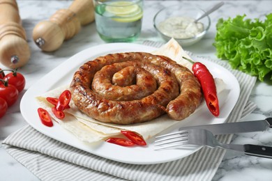 Photo of Tasty homemade sausage with chili pepper and lavash served on white marble table, closeup