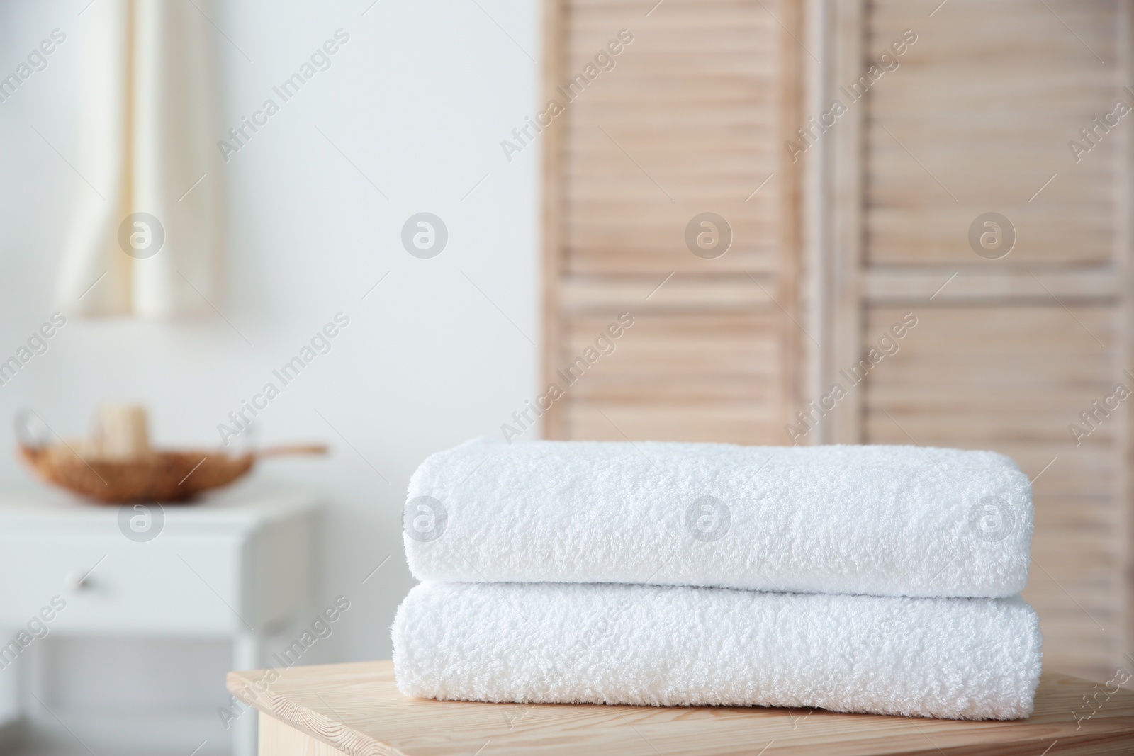 Photo of Stack of towels on table against blurred background