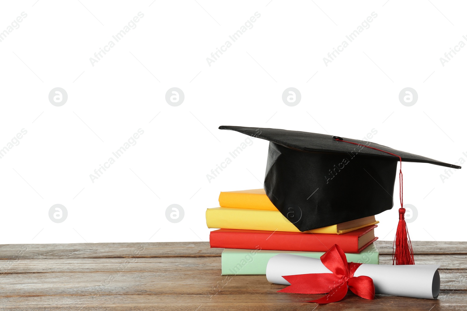 Photo of Graduation hat, books and diploma on wooden table against white background, space for text