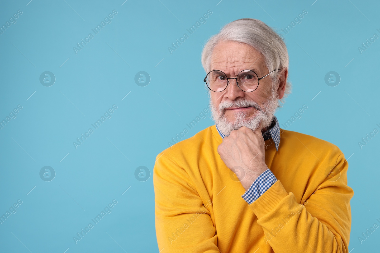 Photo of Portrait of stylish grandpa with glasses on light blue background, space for text