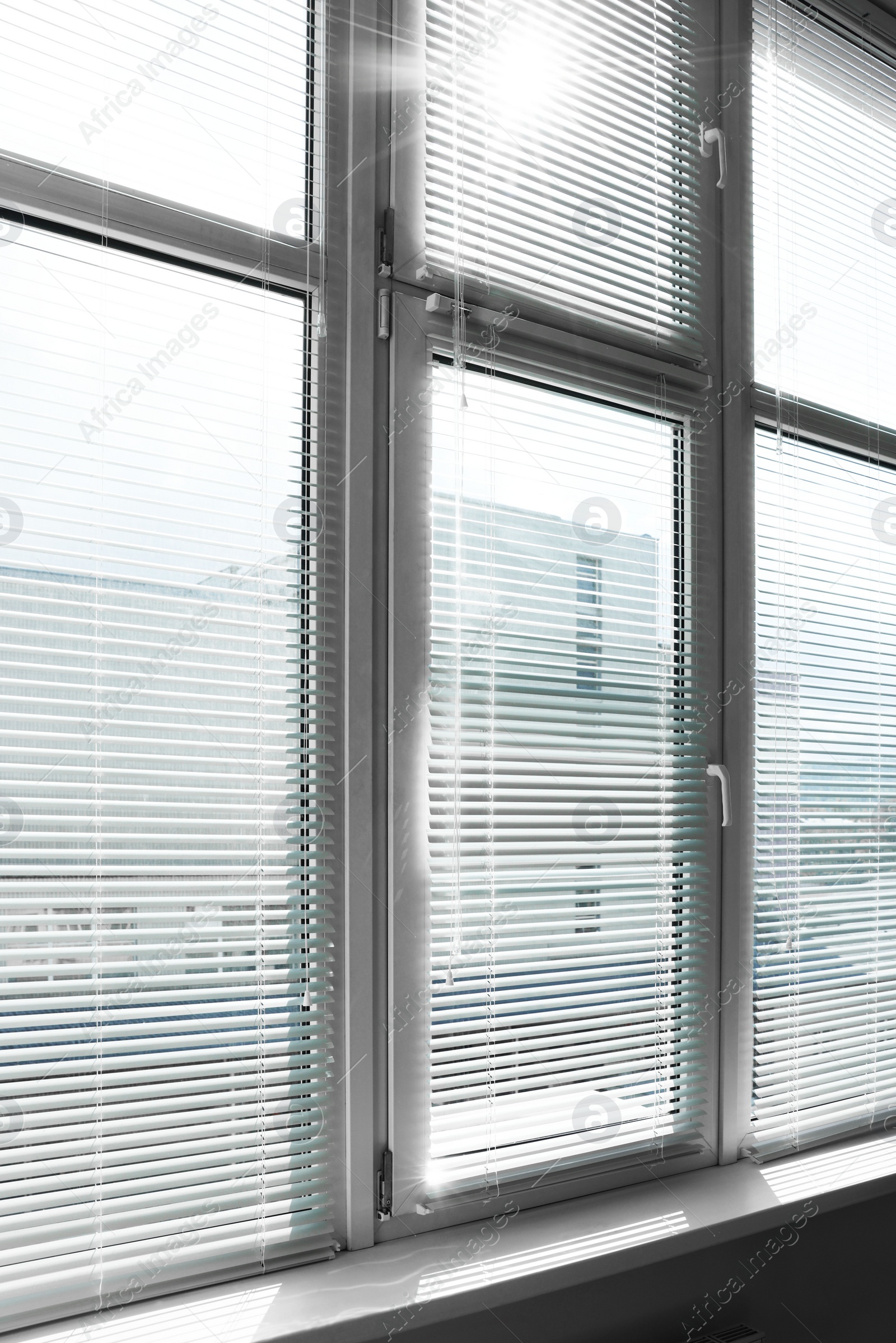 Photo of Stylish window with horizontal blinds in room