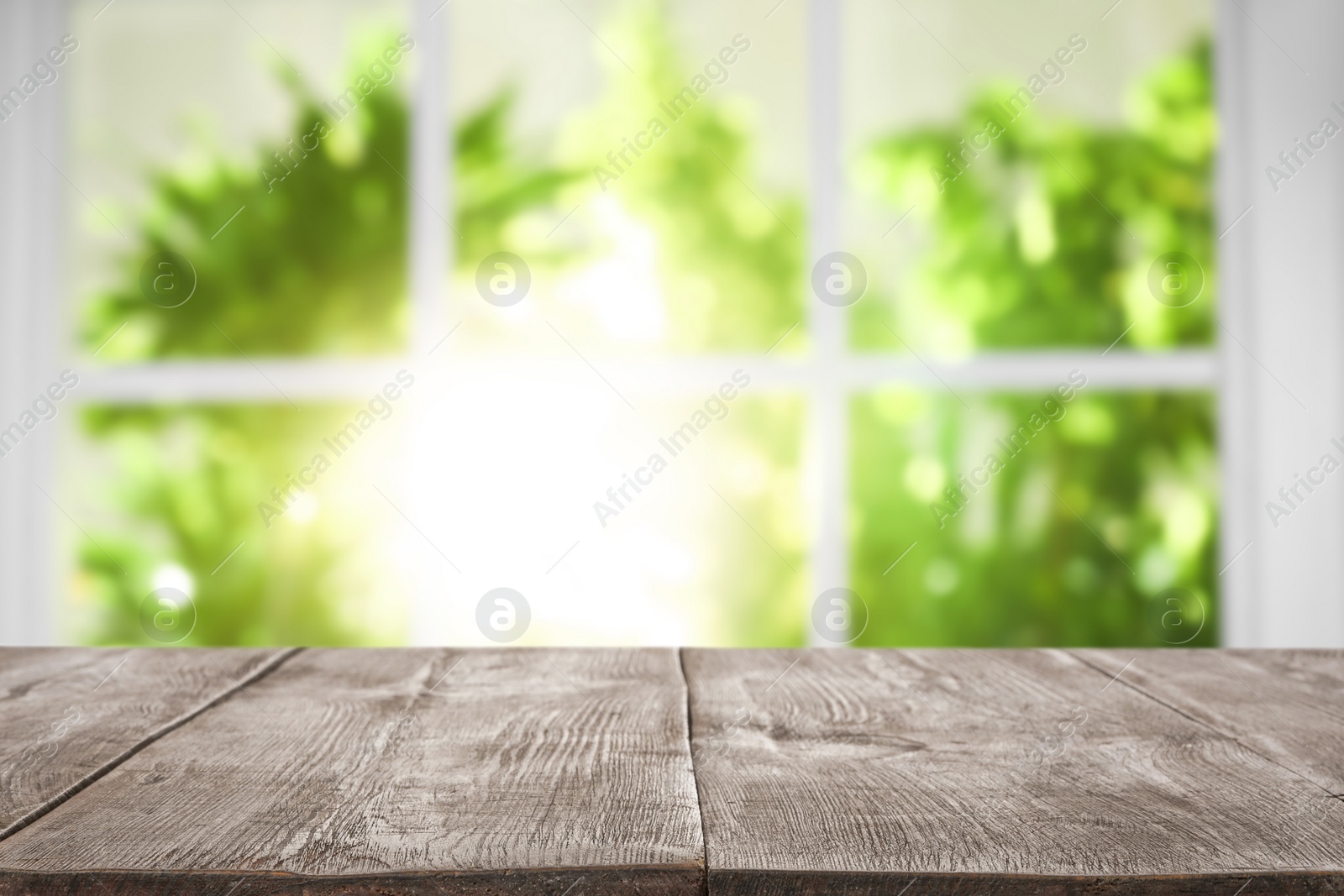 Image of Empty wooden table in front of window. Sunny morning 