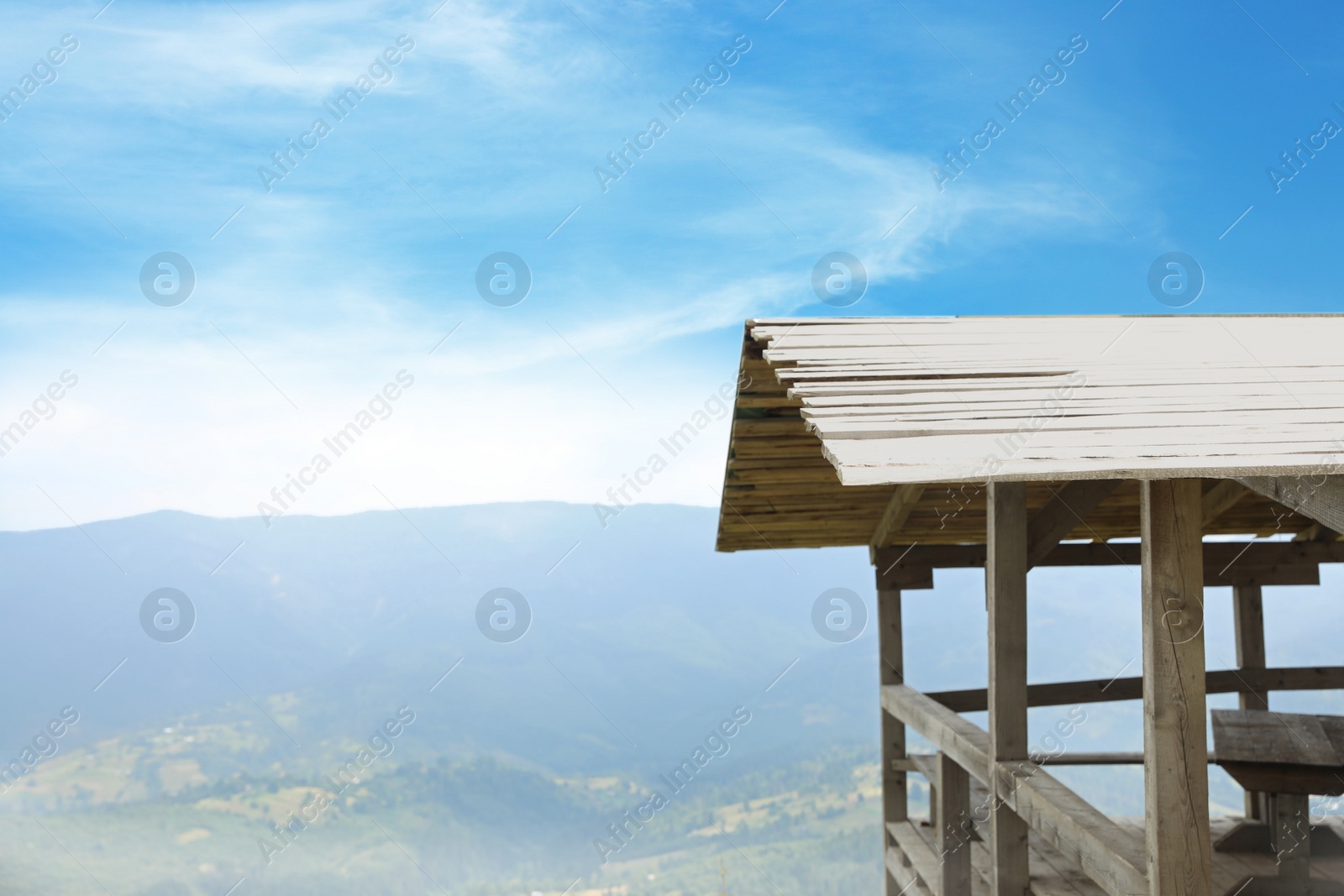 Photo of Picturesque landscape with wooden gazebo and mountain forest on background