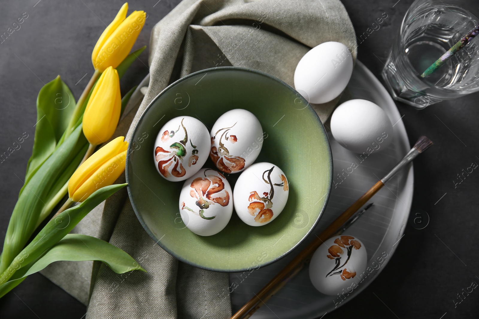 Photo of Flat lay composition with painted Easter eggs on dark table