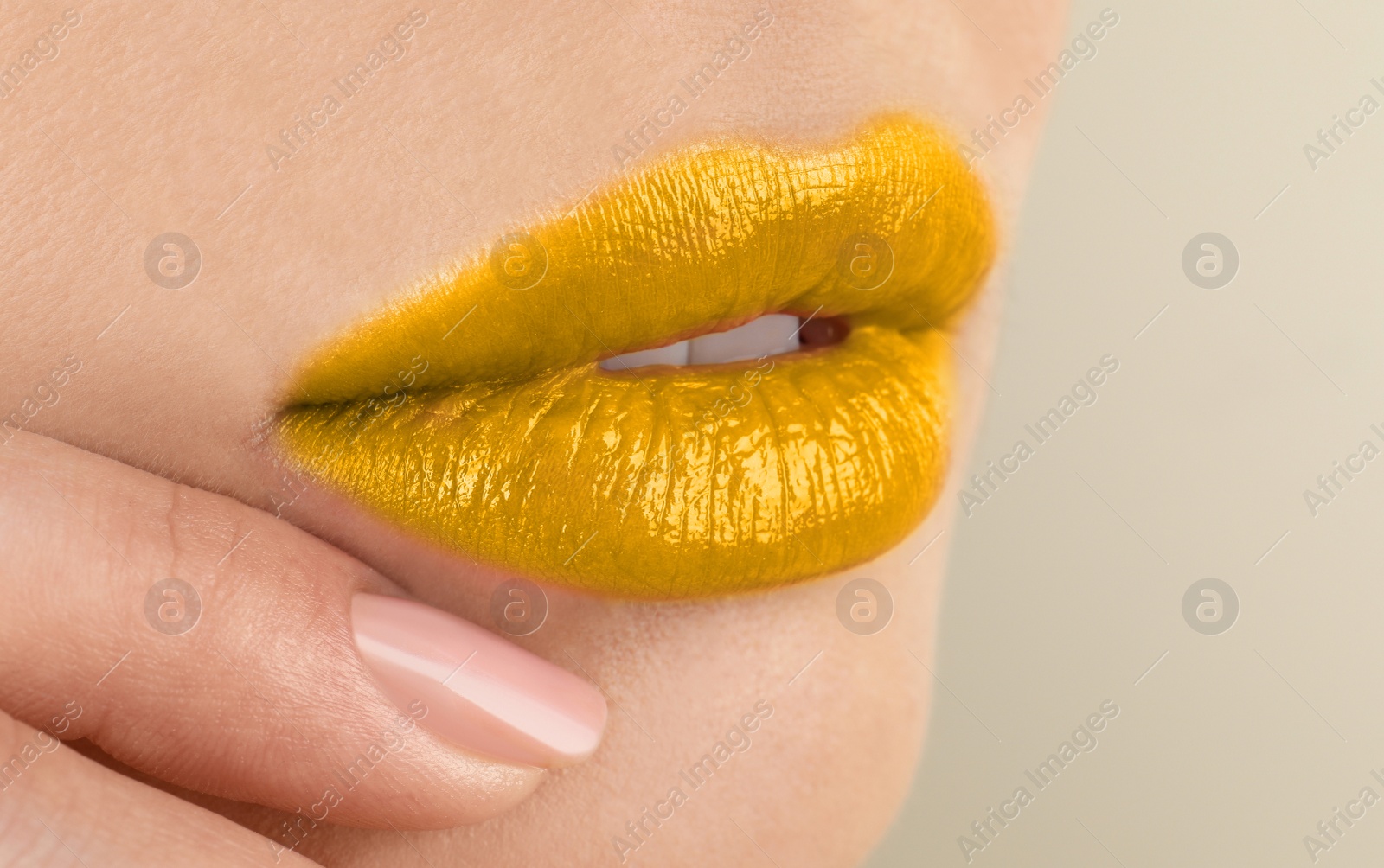 Image of Woman with golden lipstick on beige background, closeup