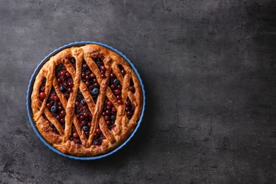 Photo of Delicious currant pie and fresh berries on grey table, top view. Space for text