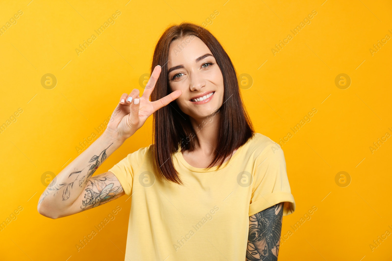 Photo of Portrait of pretty young woman with gorgeous chestnut hair and charming smile on yellow background