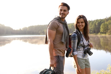 Young couple on shore of beautiful lake. Camping season