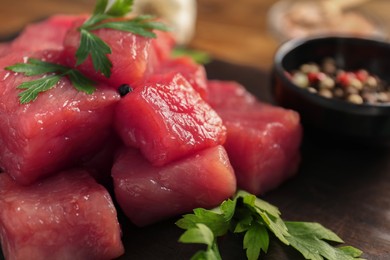 Photo of Cooking delicious goulash. Raw beef meat with parsley on table, closeup