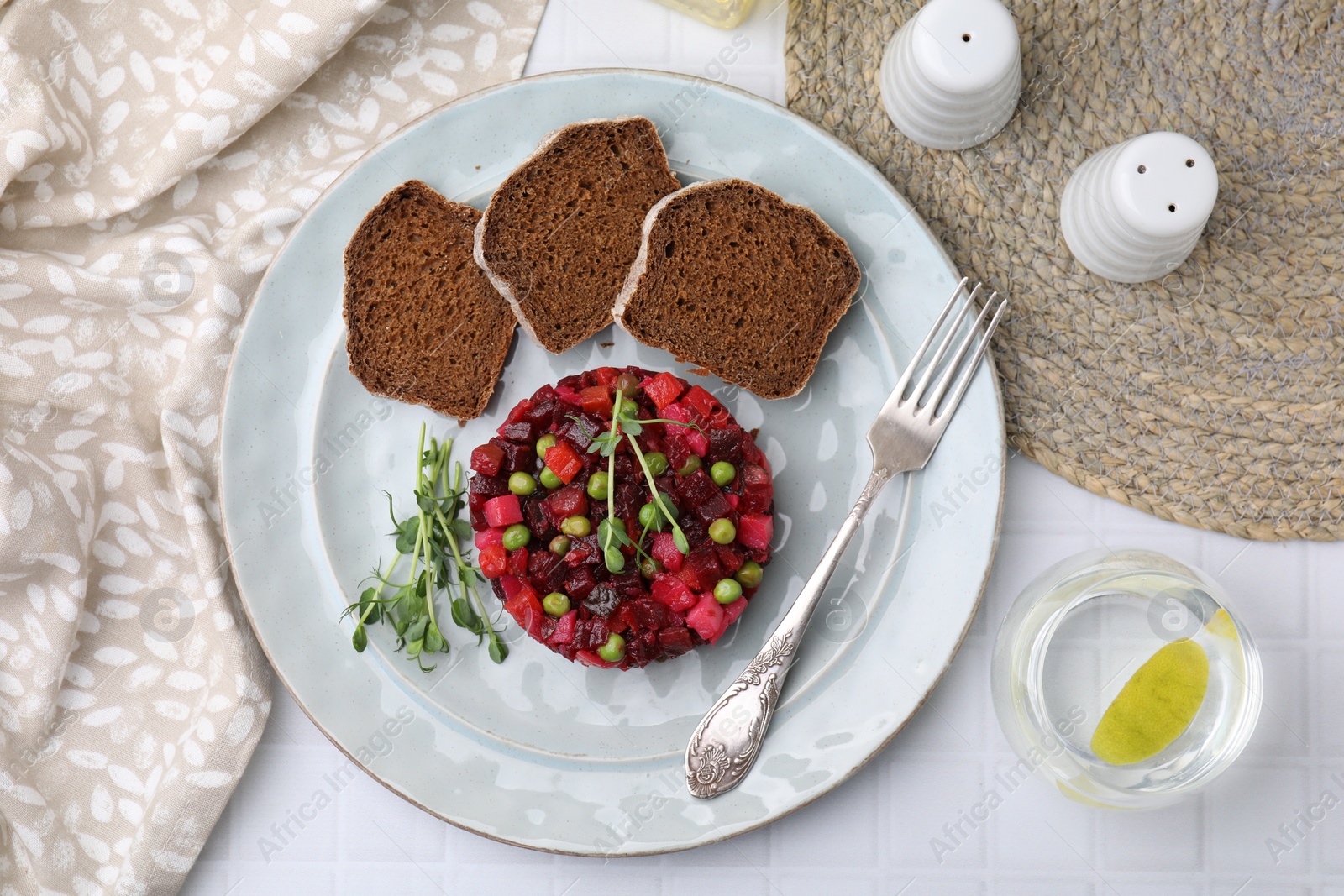 Photo of Delicious vinaigrette salad with slices of bread on white table, flat lay