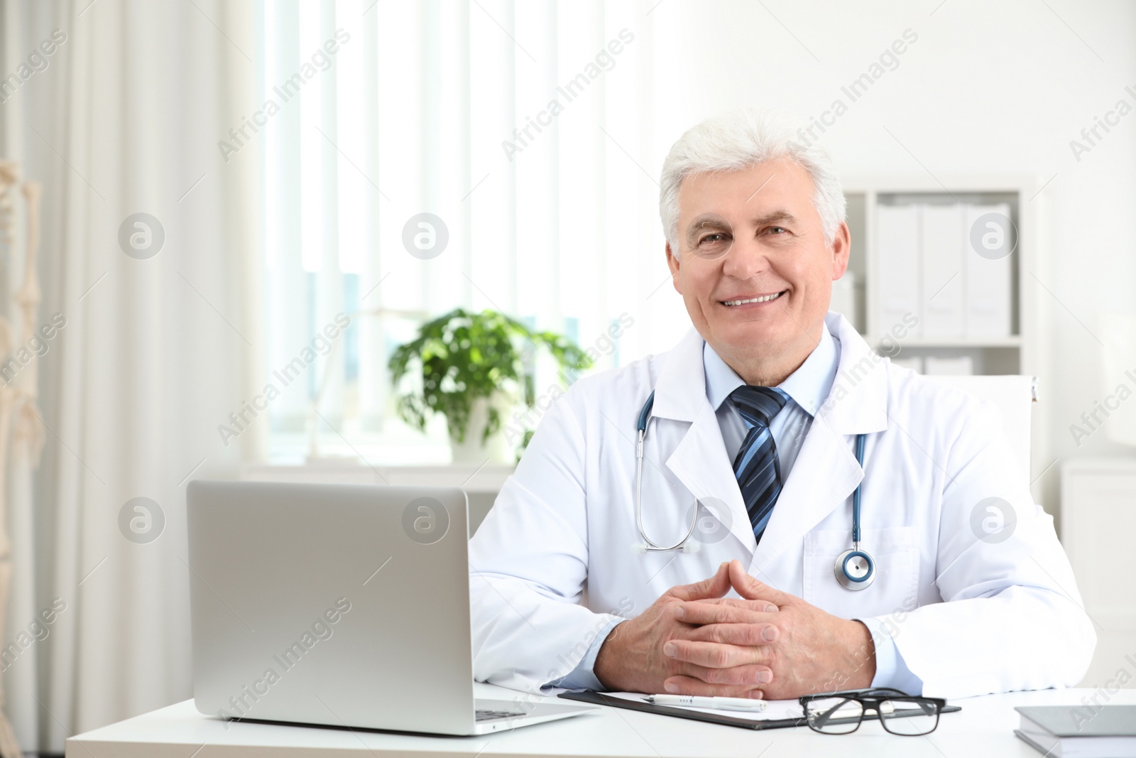 Photo of Portrait of senior doctor in white coat at workplace