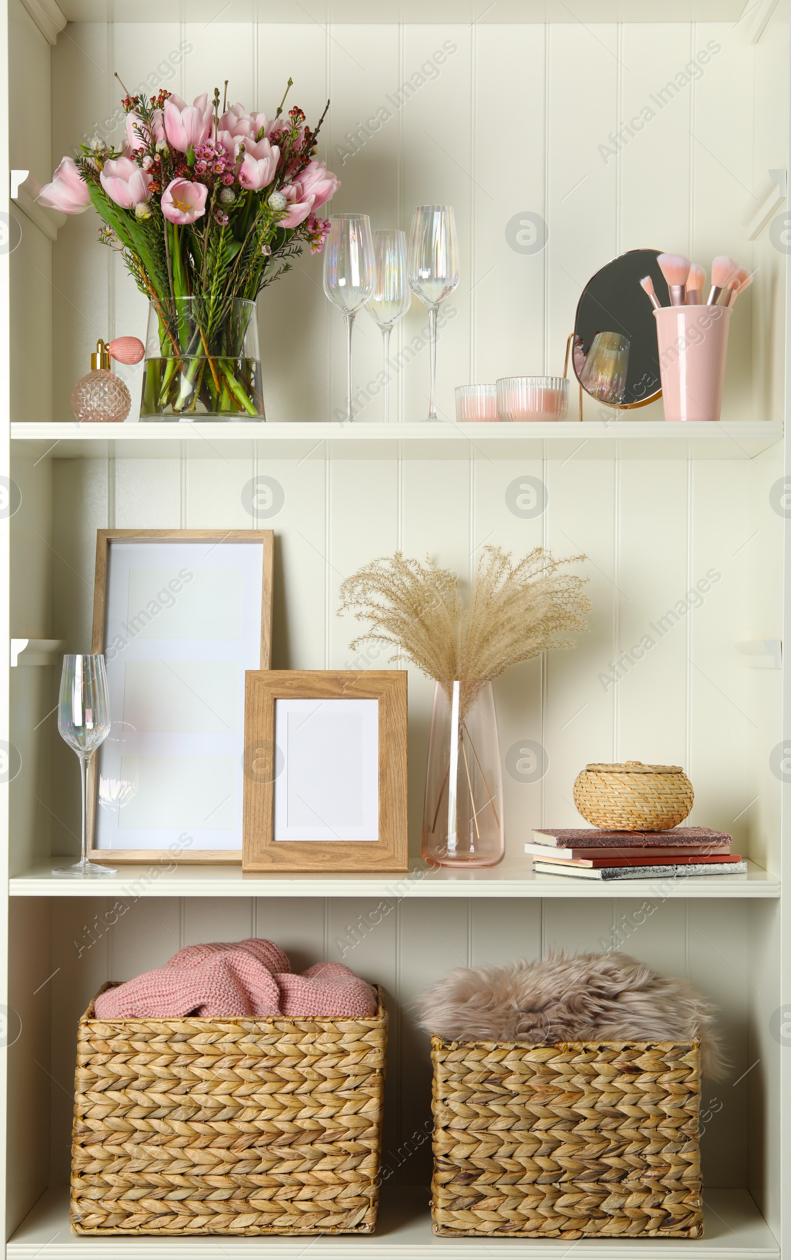 Photo of White shelving unit with glassware and different decorative elements