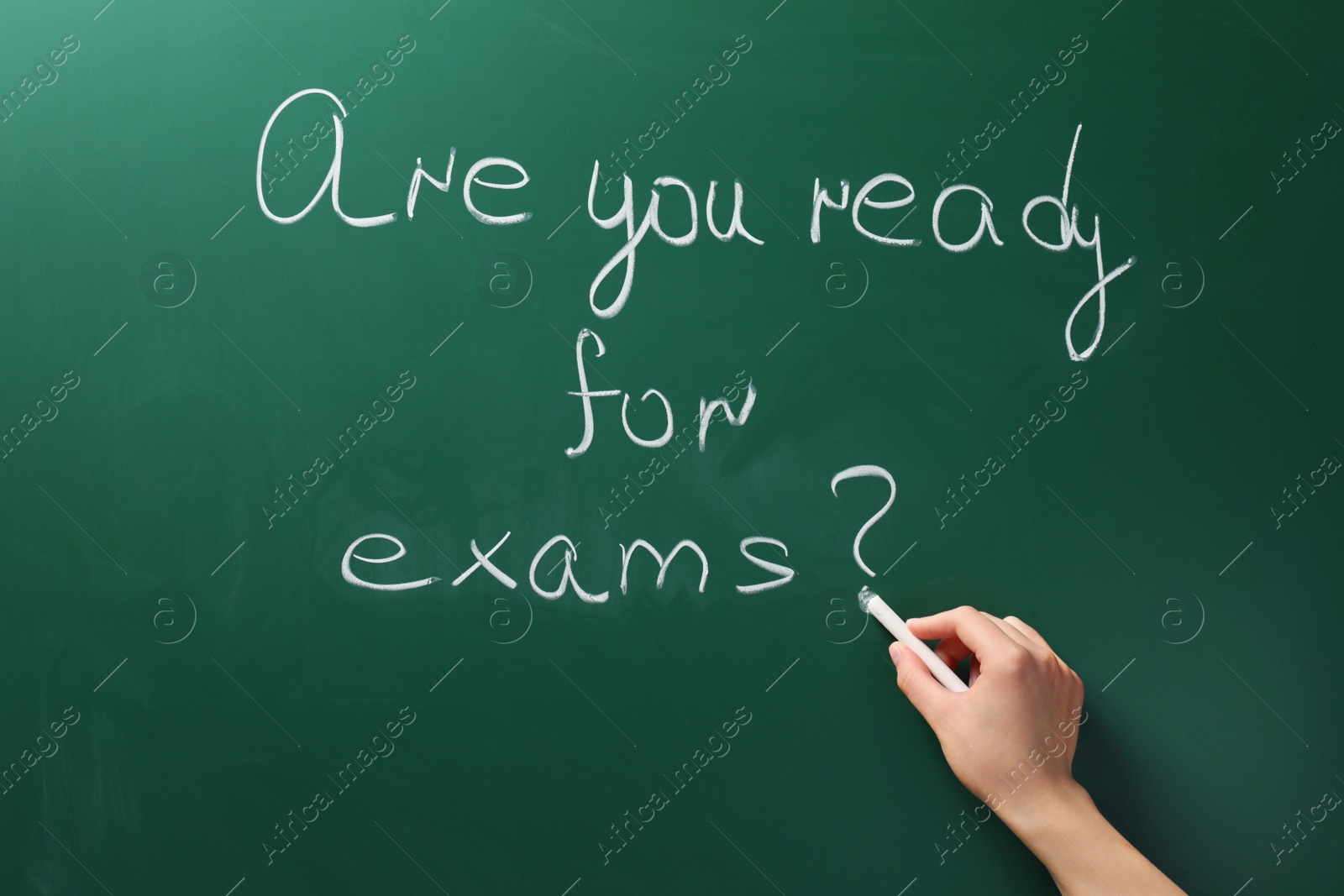 Photo of Woman writing phrase Are You Ready For Exams on green chalkboard, closeup