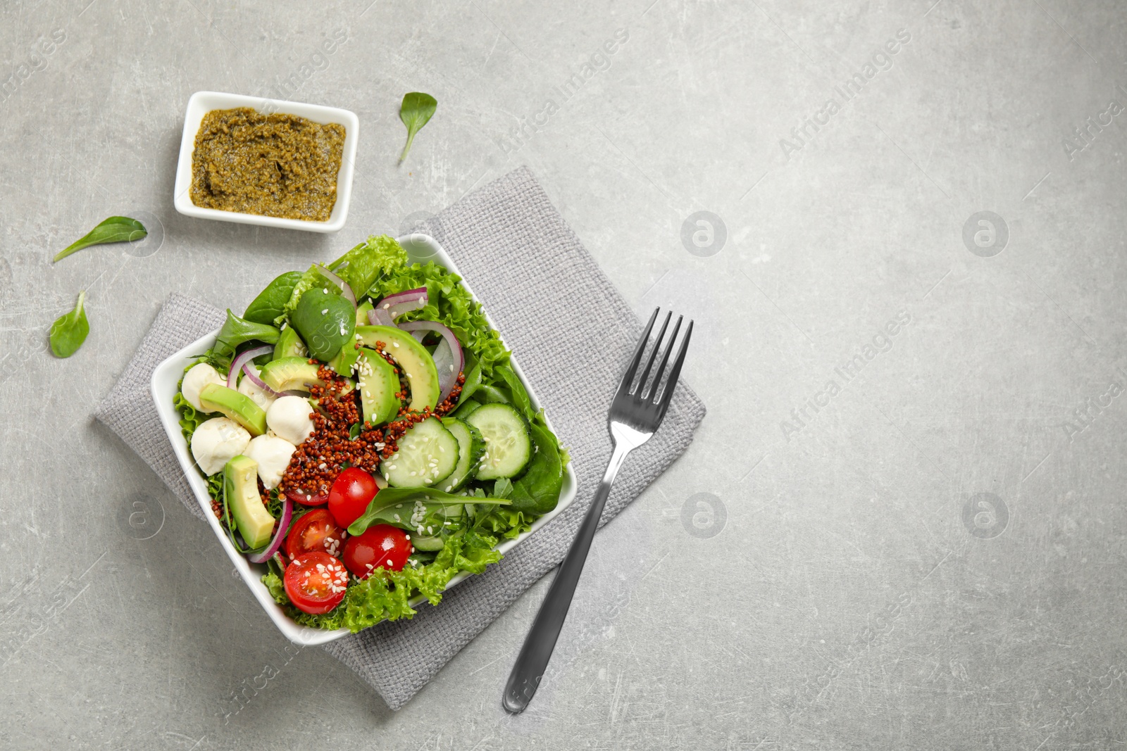 Photo of Delicious avocado salad with quinoa on light grey table, flat lay