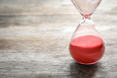 Hourglass with flowing sand on table. Time management