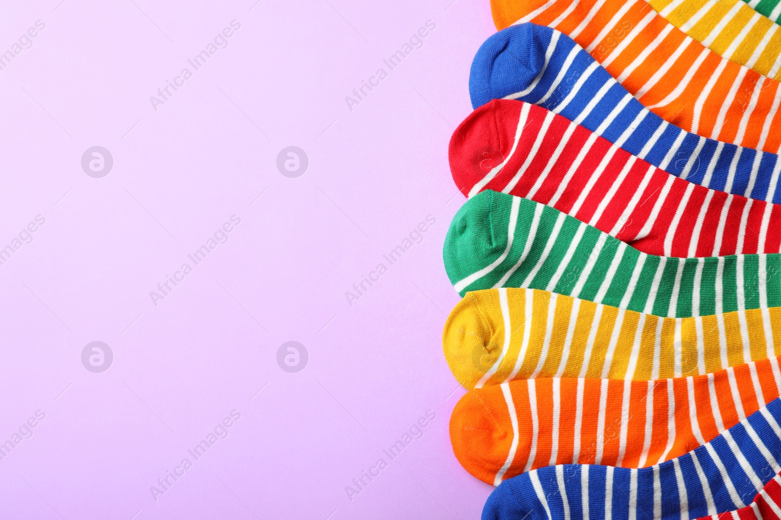 Photo of Cute child socks and space for text on color background, top view