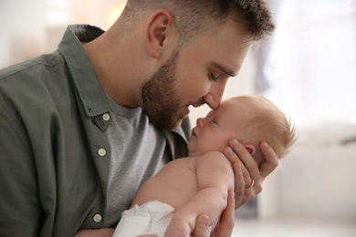 Photo of Father with his newborn son at home