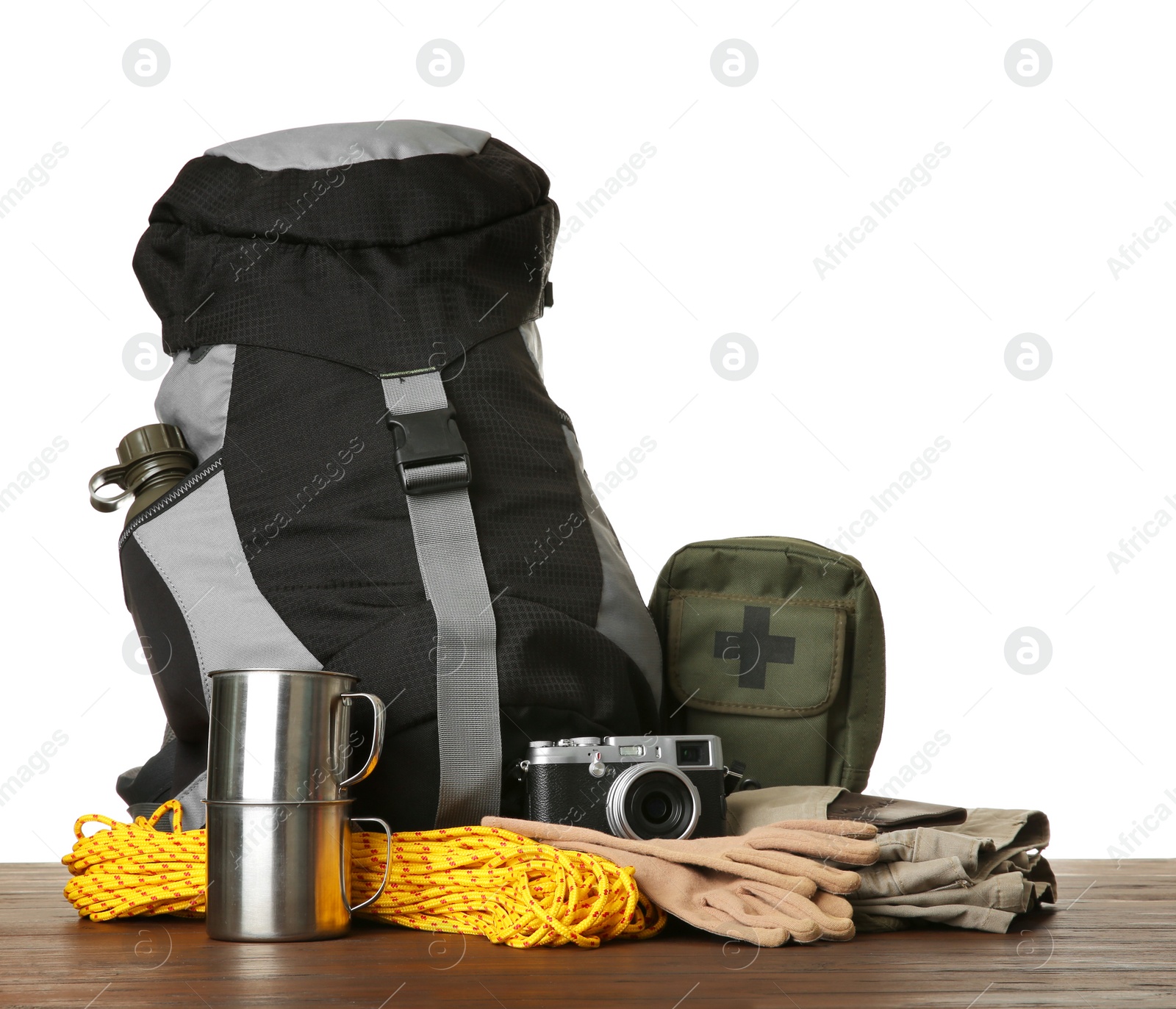 Photo of Set with different camping equipment on wooden table against white background