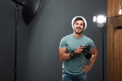 Professional photographer with modern camera in studio