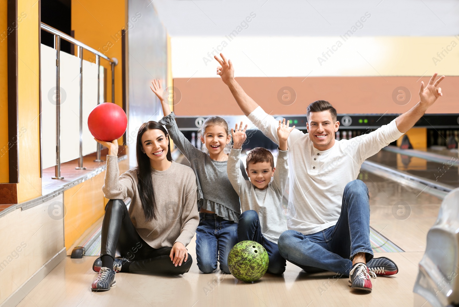 Photo of Happy family spending time together in bowling club