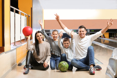 Photo of Happy family spending time together in bowling club