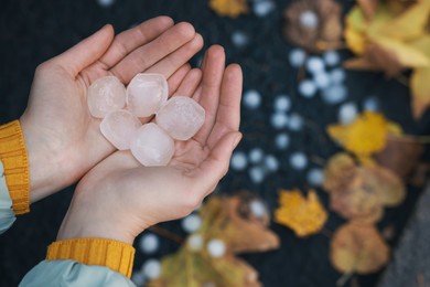 Photo of Woman holding hail grains after thunderstorm outdoors, closeup
