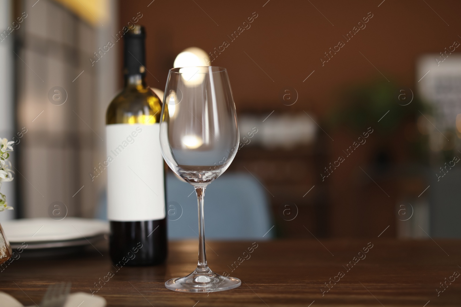 Photo of Glass and bottle of wine on table in restaurant