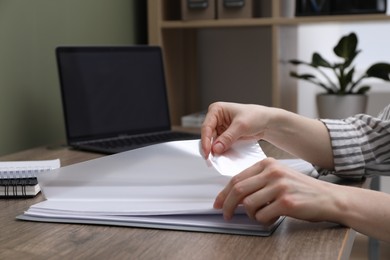 Photo of Woman with punched pockets at wooden table, closeup