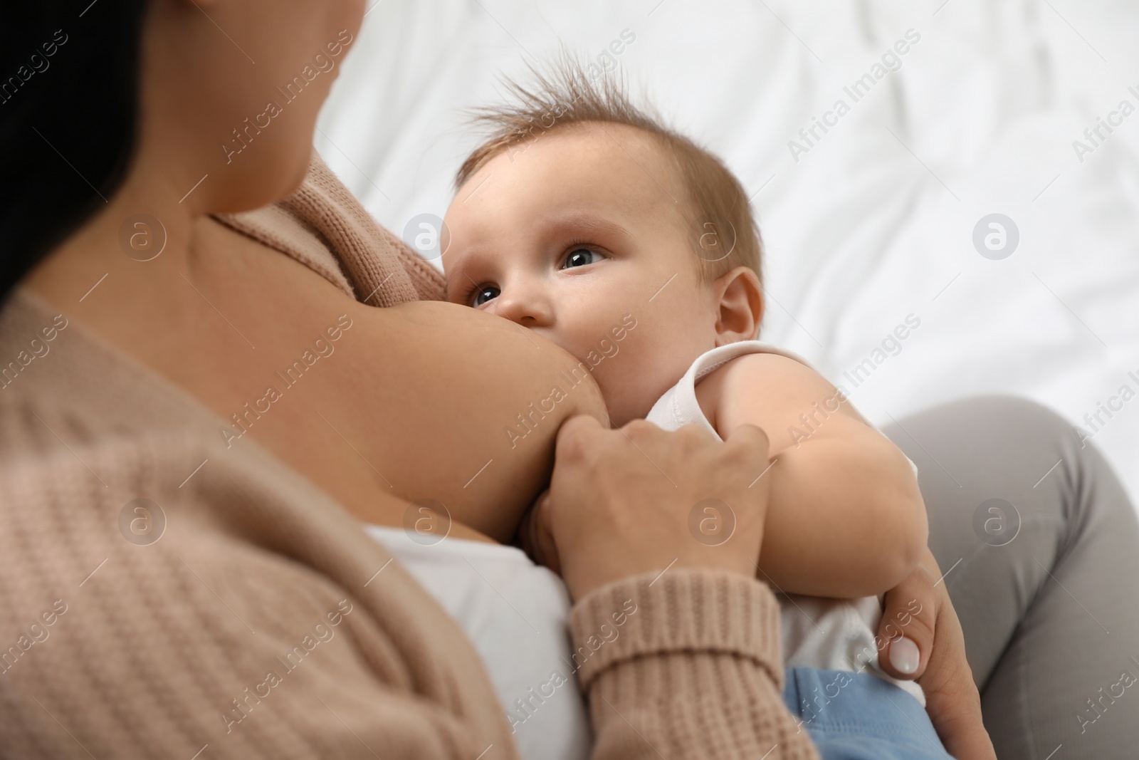 Photo of Woman breastfeeding her little baby at home