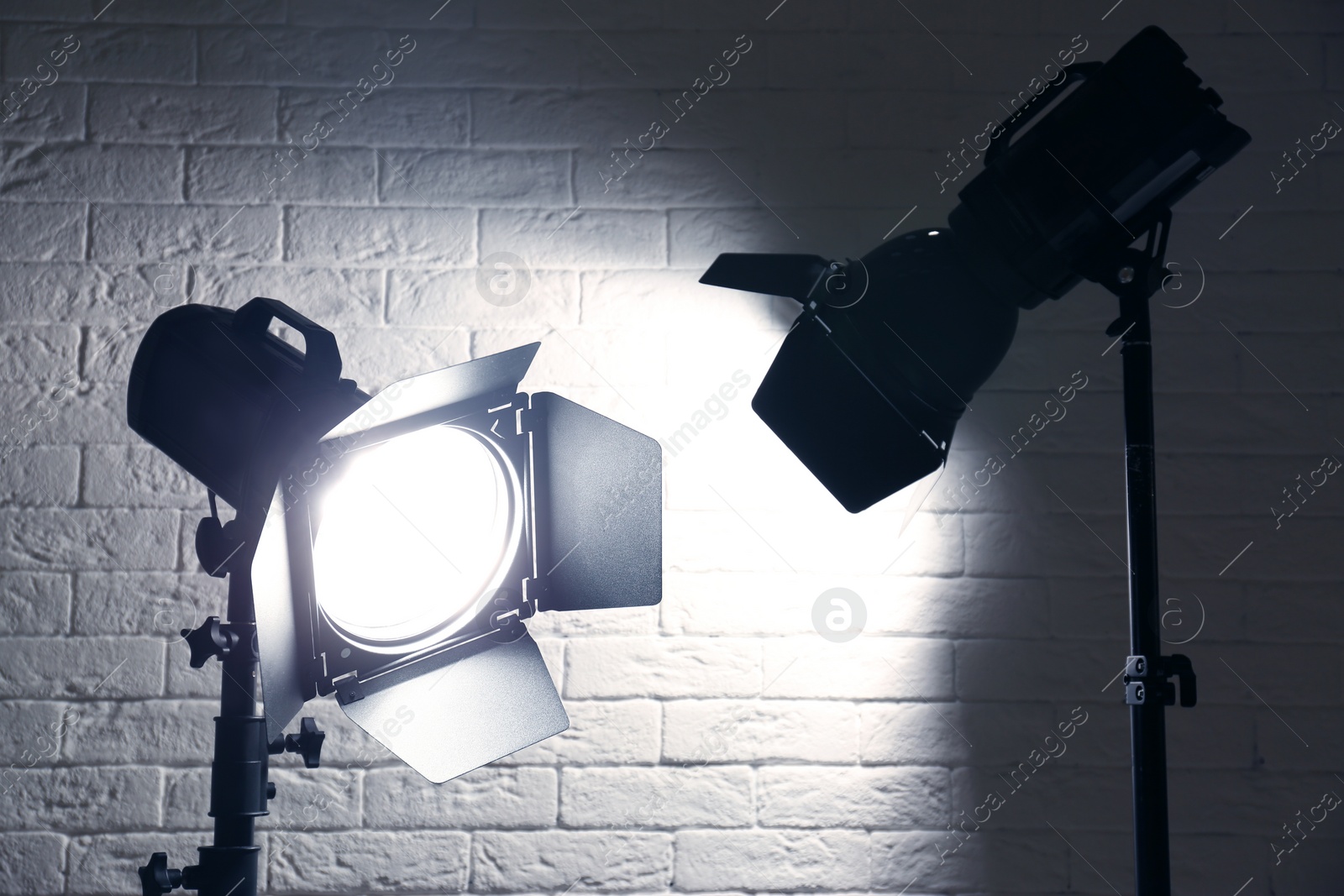 Photo of Professional photo studio lighting equipment near brick wall