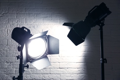 Photo of Professional photo studio lighting equipment near brick wall