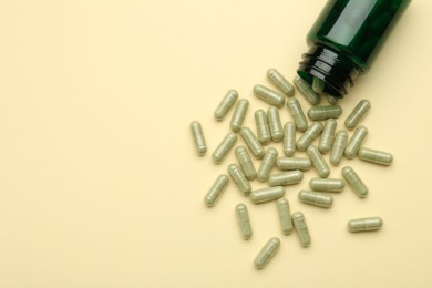 Photo of Vitamin pills and bottle on beige background, top view. Space for text