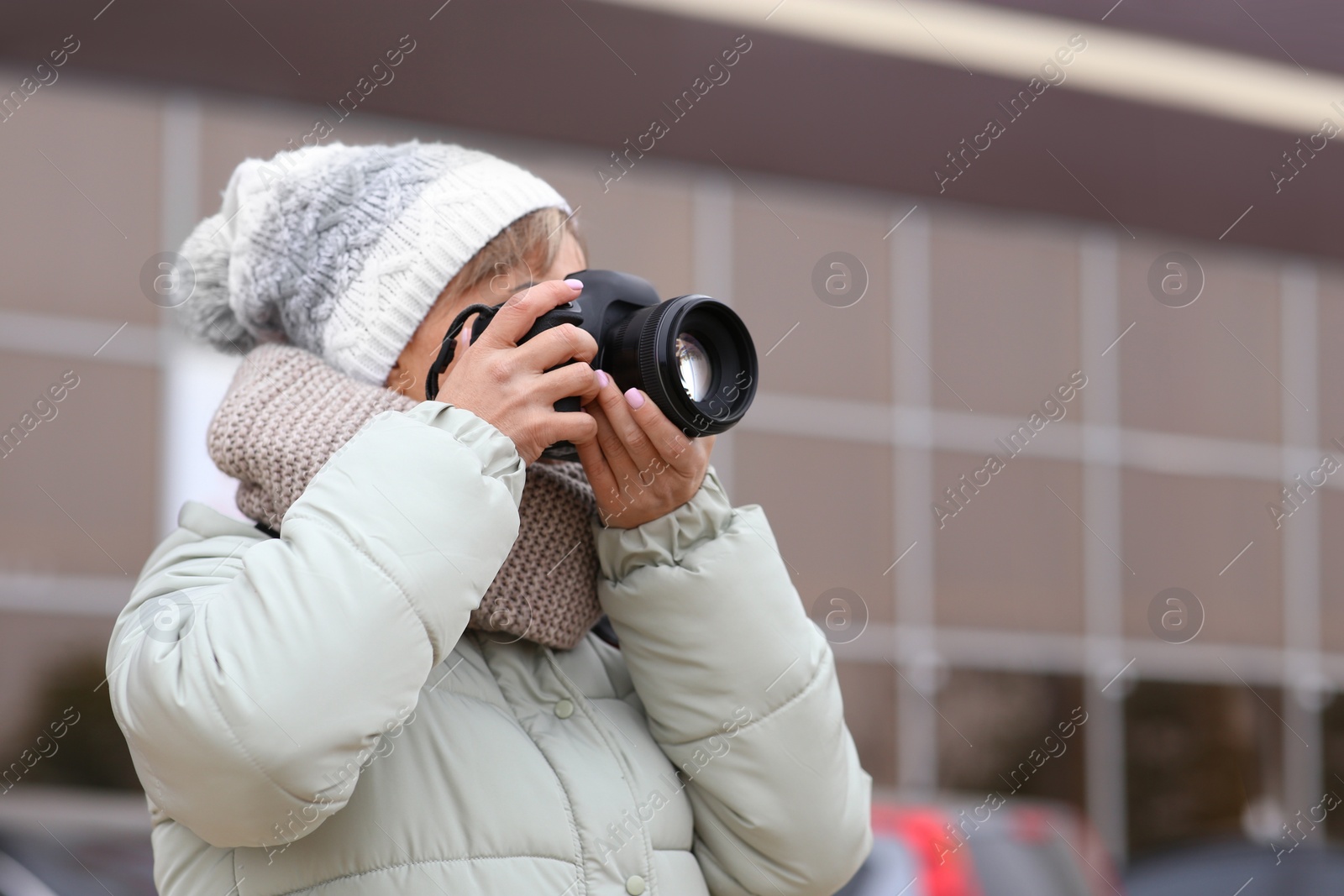 Photo of Photographer taking photo with professional camera outdoors