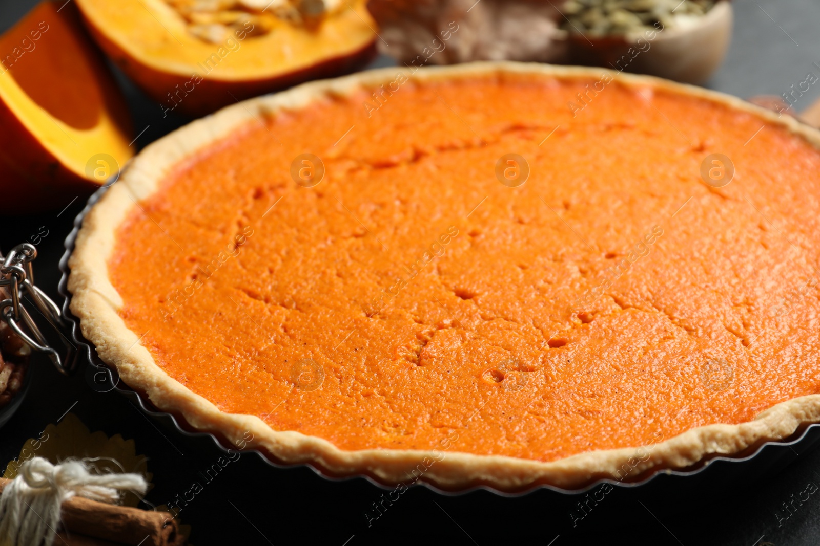 Photo of Delicious homemade pumpkin pie on black table, closeup