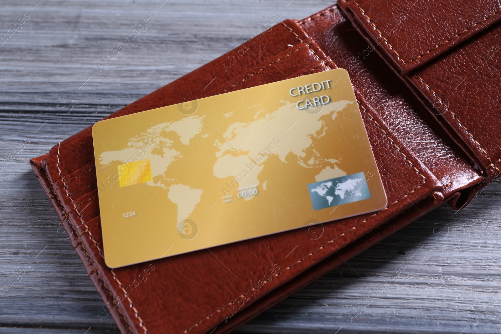 Photo of Credit card and leather wallet on grey wooden table