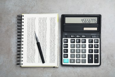 Photo of Calculator, pen and notebook with data on grey table, flat lay