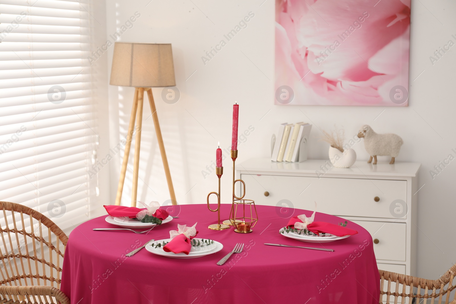 Photo of Beautiful table setting with green branches and burning candles in dining room