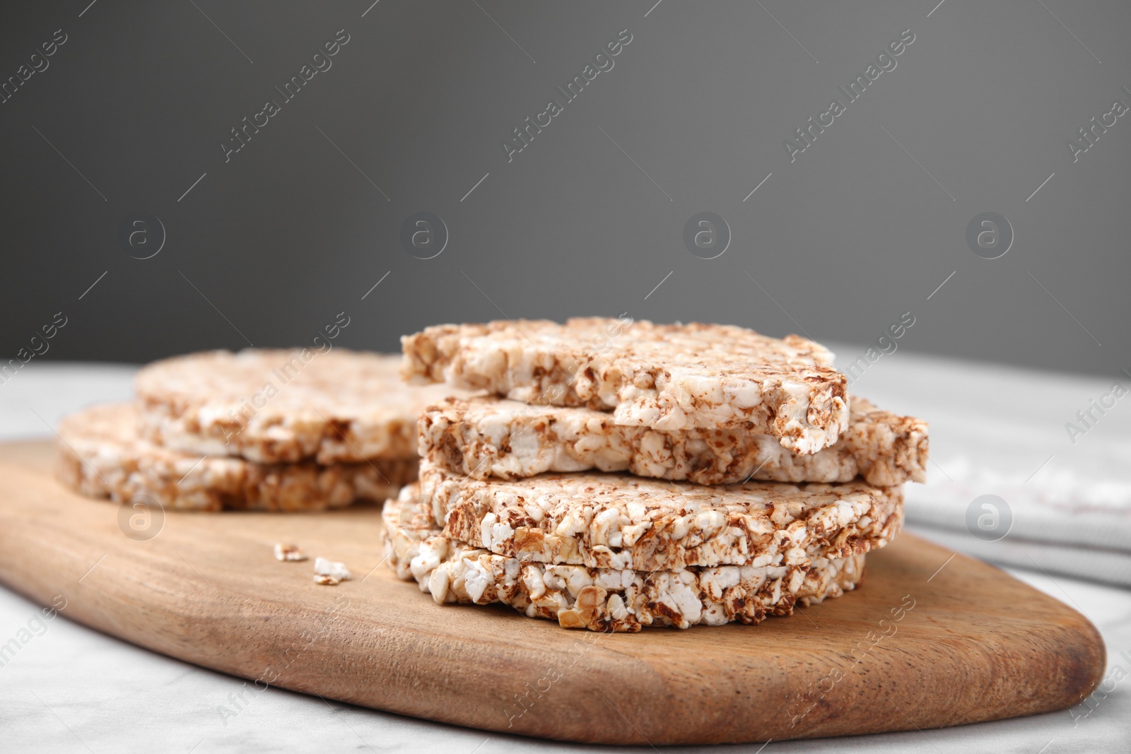 Photo of Crunchy buckwheat cakes on wooden board, closeup
