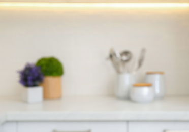 Photo of Blurred view of modern kitchen with utensils and houseplants