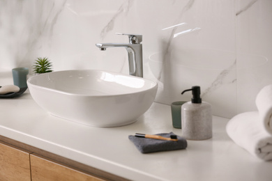 Stylish vessel sink on light countertop in modern bathroom