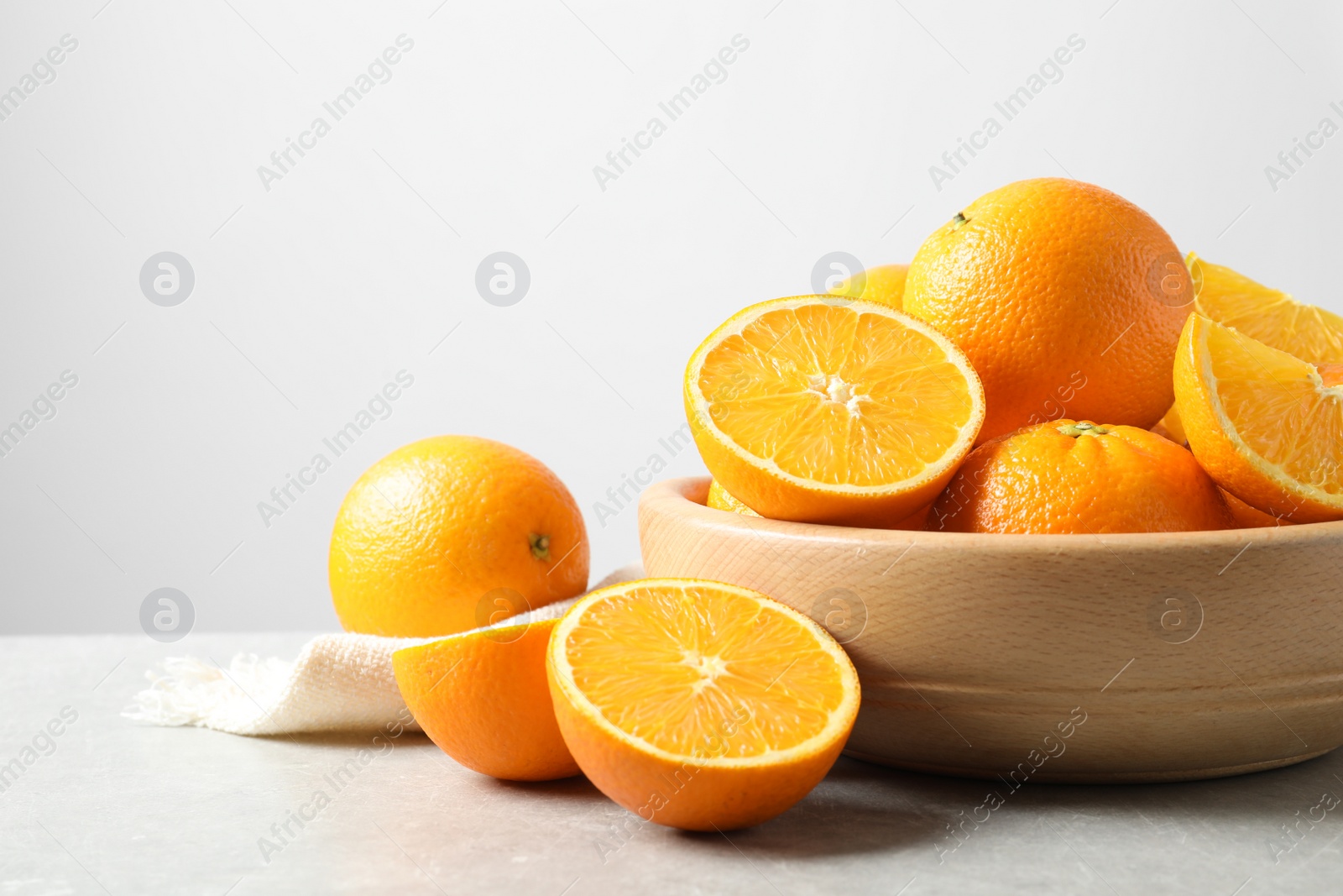 Photo of Composition with ripe oranges on table against light background. Space for text