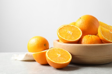 Composition with ripe oranges on table against light background. Space for text