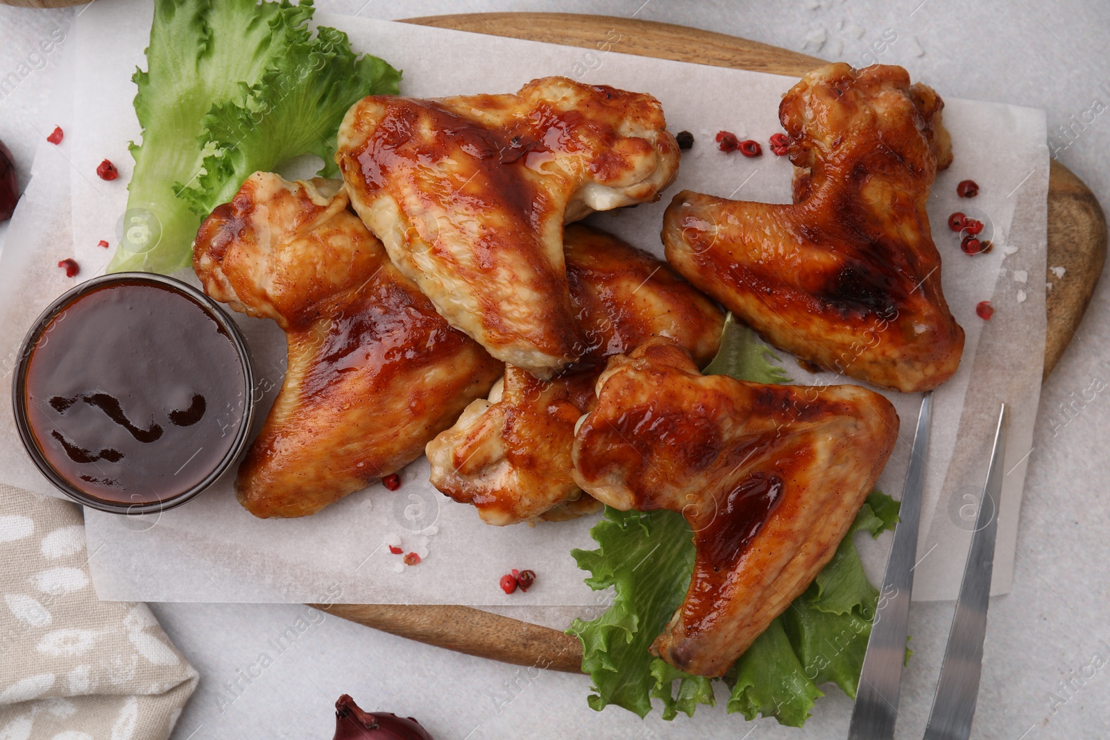 Photo of Fresh marinade, chicken wings and lettuce on light table, top view