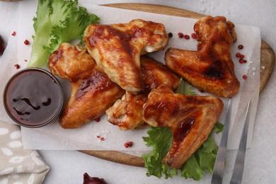 Photo of Fresh marinade, chicken wings and lettuce on light table, top view