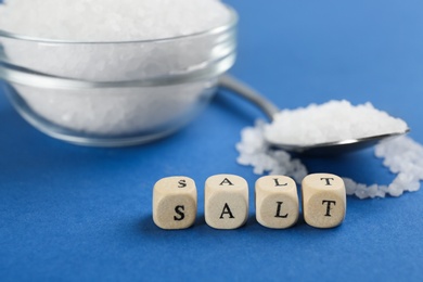 Photo of Word SALT made with cubes on blue background, closeup