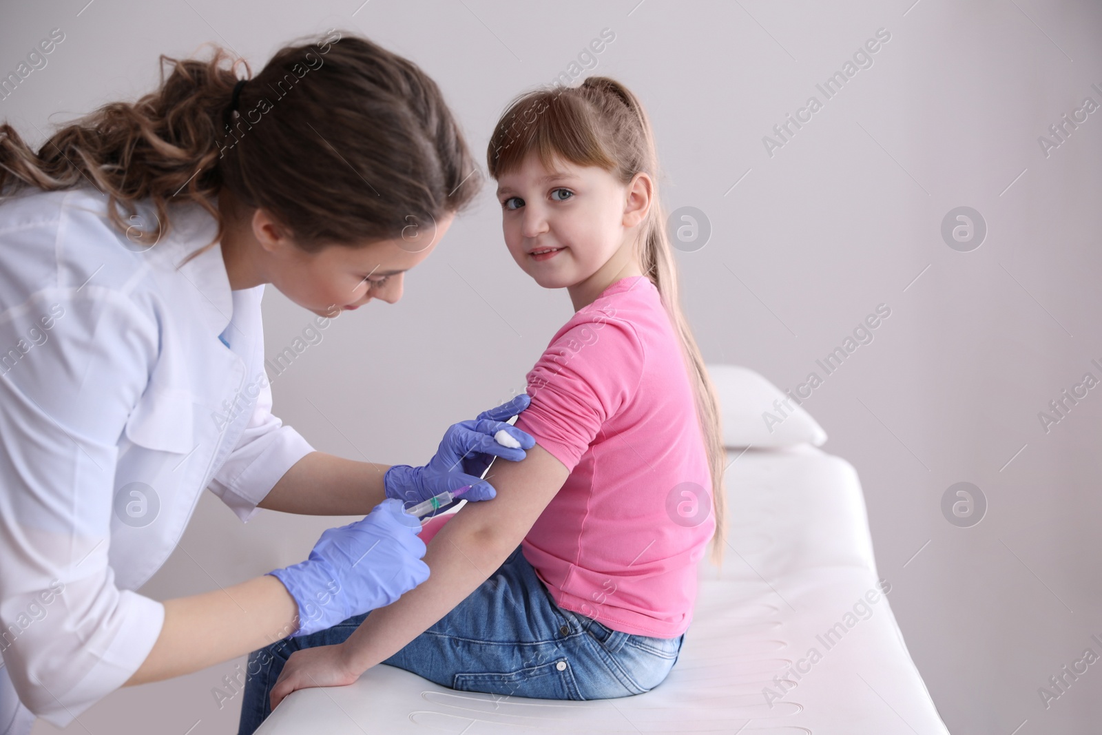 Photo of Little girl receiving chickenpox vaccination in clinic. Varicella virus prevention