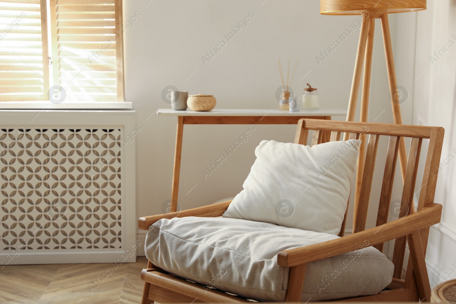 Photo of Comfortable wooden armchair near window in room. Interior design
